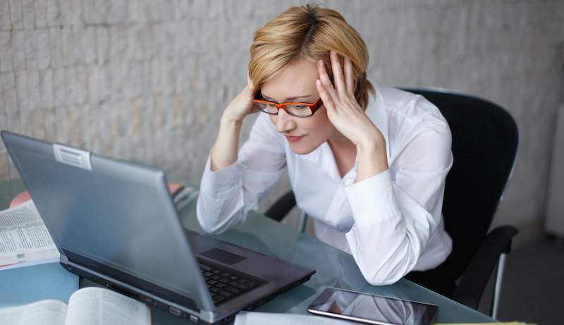 Stressed blonde businesswoman with laptop